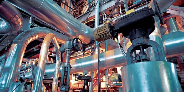 Gezeigt wird ein komplexes Anlagensystem mit Rohrleitungen in einem Industriebetrieb. Das Bild ist von nostal6ie / Shutterstock.com